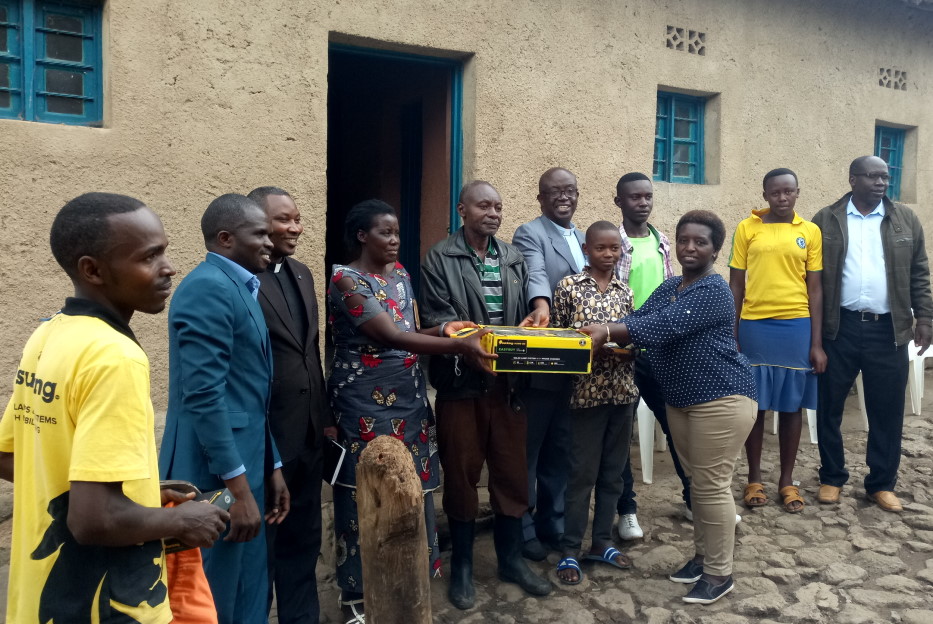 The mayor handing over a SHS kit to the first family of Mr Laurent Murindabigwi in Kamonyi village